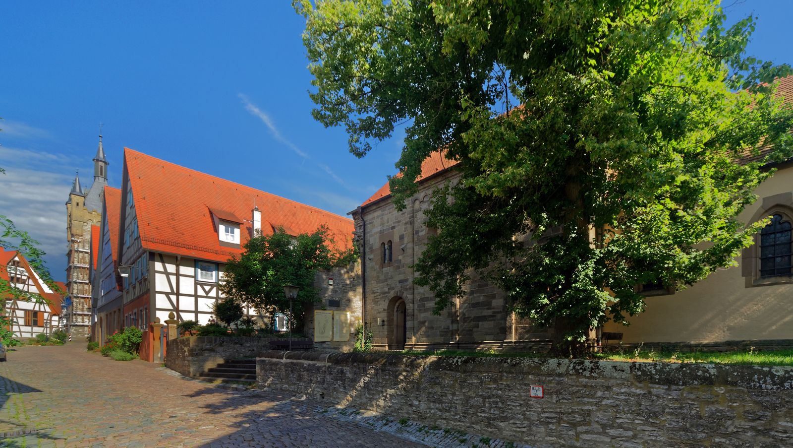 Gasse in der Altstadt von Bad Wimpfen am Berg mit Fachwerkh&auml;usern, roten Ziegeld&auml;chern und dem Blauen Turm im Hintergrund