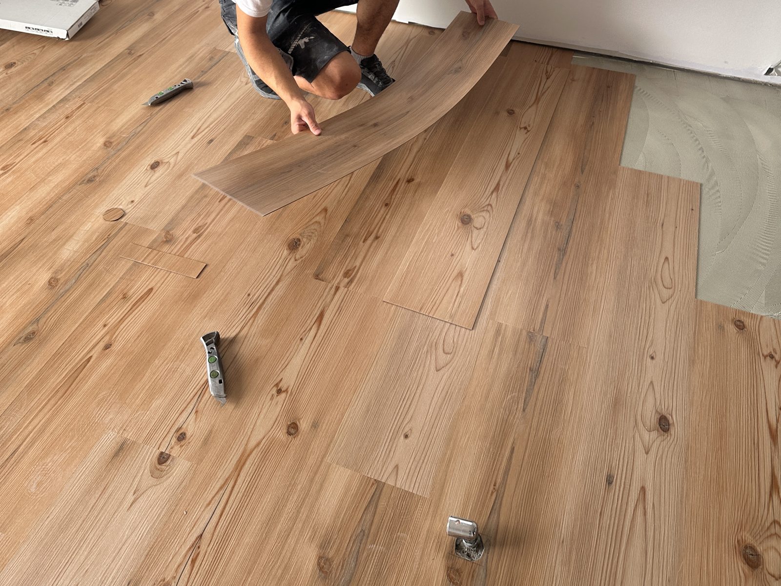 Designboden in Holzoptik wird Planke für Planke ins Kleberbett gelegt