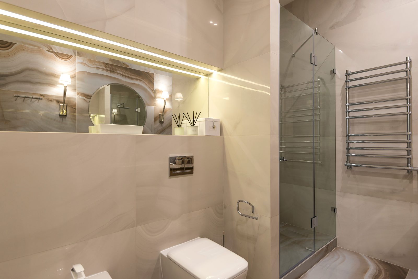 Modernes Bad mit Großformatfliesen in Marmoroptik, bodengleicher Dusche hinter Glas und Handtuchheizkörper