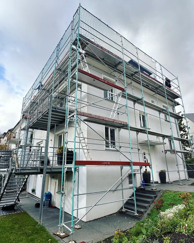 Wei&szlig;es Wohnhaus, Ger&uuml;st &uuml;ber vier Lagen, an der obersten Lage rundum ein Netz