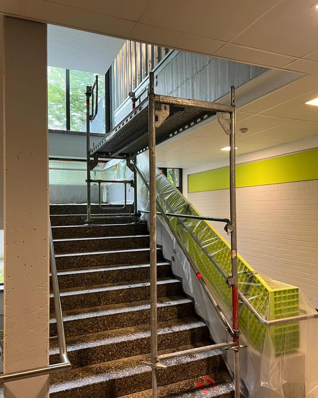 Ger&uuml;st &uuml;ber einer Treppe im Treppenhaus, die St&uuml;tzen stehen auf den Stufen, das Gel&auml;nder ist mit Folie abgedeckt
