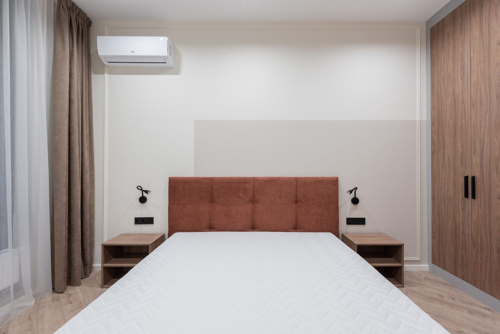 Helles Schlafzimmer mit einem Split-Klimager&auml;t an der Wand &uuml;ber dem Bett