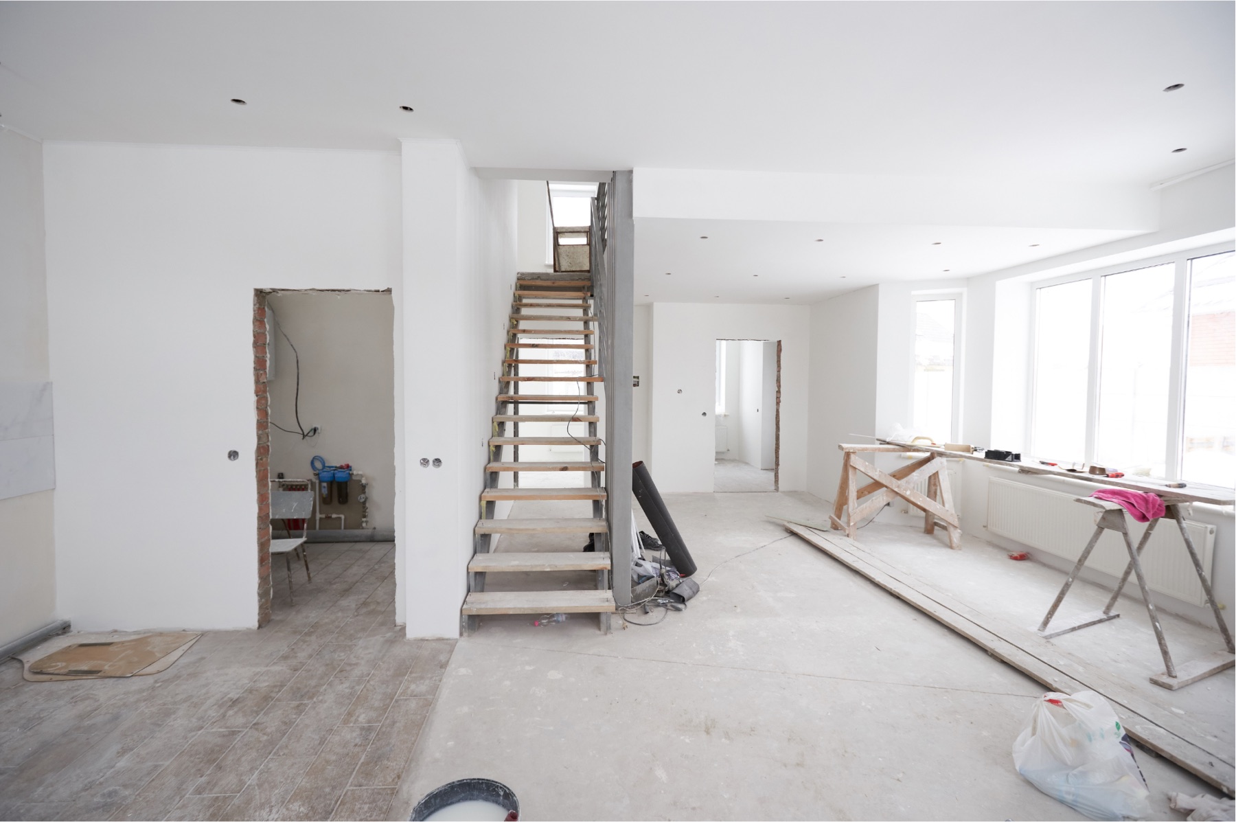 Wohnung im Rohbauzustand w&auml;hrend der Sanierung mit freigelegter Treppe und verputzten W&auml;nden