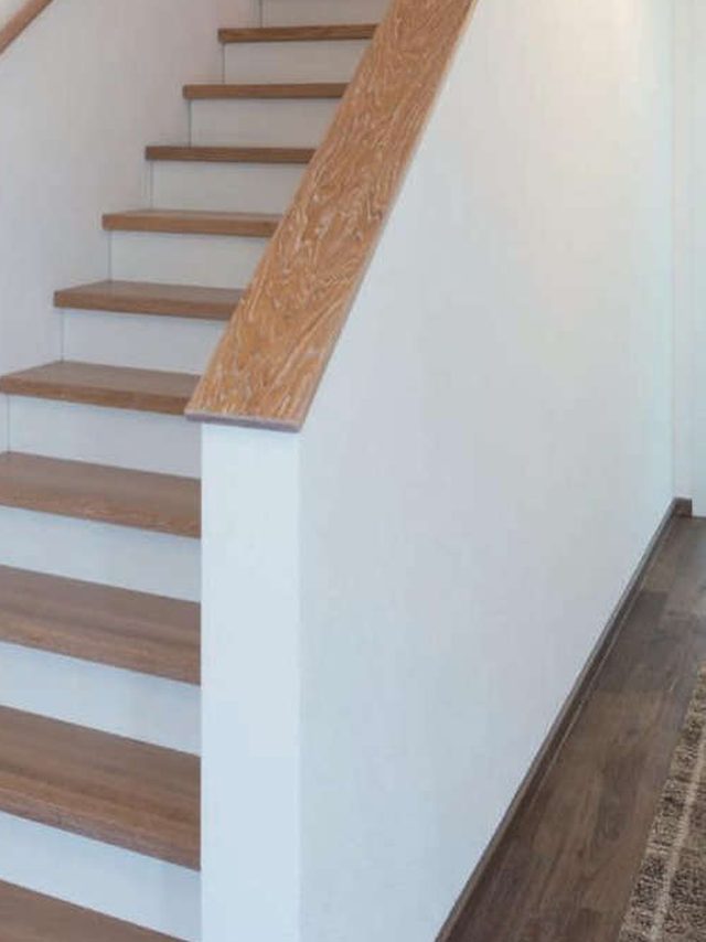 Geschlossene Stufen mit weißen Setzstufen und Holzauftritten, Handlauf an der Wange