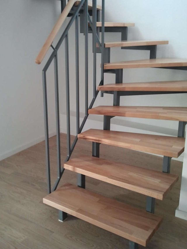 Holmtreppe: offene Holzstufen auf grauen Stahlholmen, Geländer aus Stäben