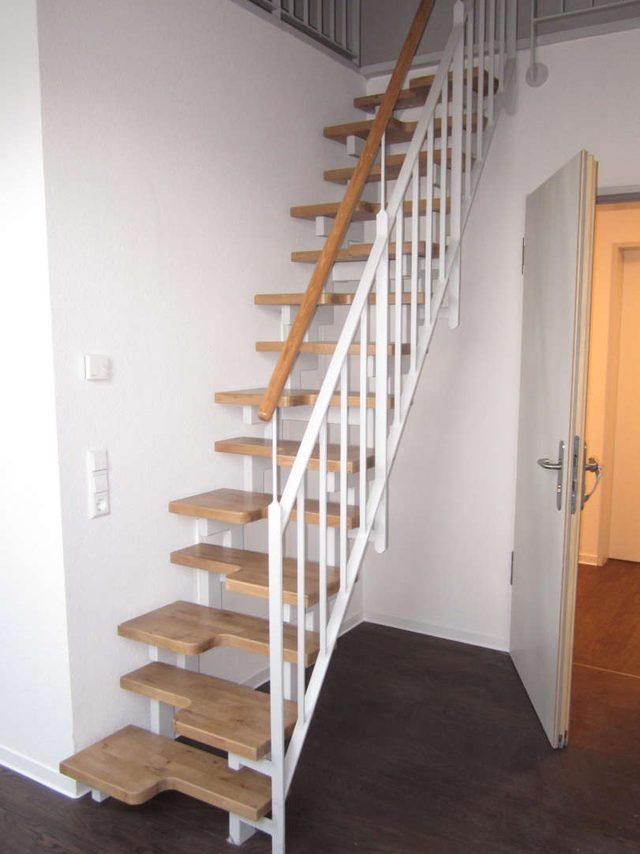 Weiße Raumspartreppe mit schmalen Holzstufen auf einem Mittelholm, steil in den Dachraum führend