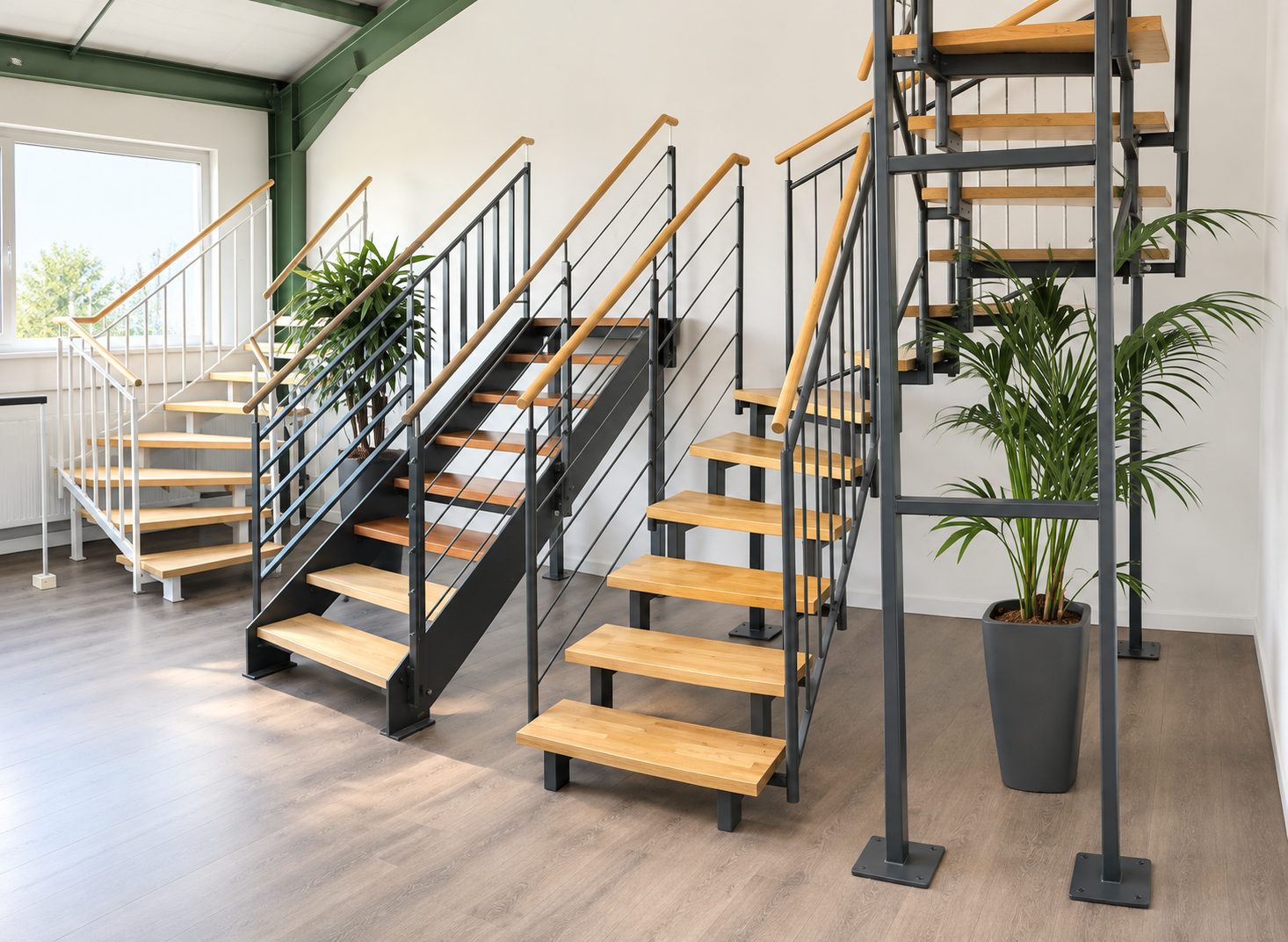 Vier Treppen nebeneinander: Holzstufen auf Stahl &ndash; eine mit Wange, zwei auf dem Mittelholm, eine gewendelt &ndash; mit Gel&auml;ndern aus senkrechten St&auml;ben oder waagerechten Seilen